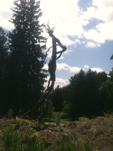 This metallic figure at a sculpture park is beautifully displayed adjacent to the towering pine tree surrounded by beautiful floral gardens. The lines within the sculpture flow beautifully to make this a piece of art work that makes an impression.